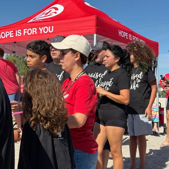 Candidatos ao batismo com camisetas 'raised to life' antes de entrar no mar
