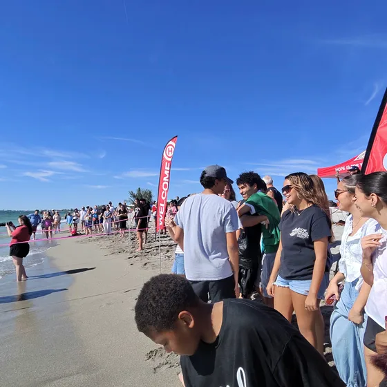 Igreja reunida na faixa de areia de Turtle Beach acompanhando os batismos