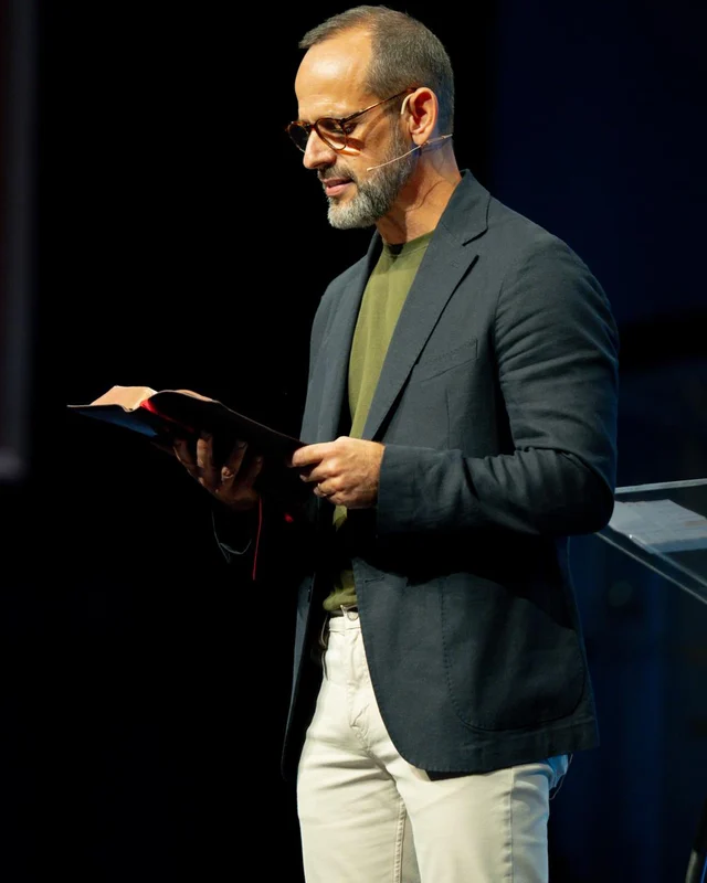 Pastor Márcio Gonçalves pregando com a Bíblia aberta na mão, na Igreja Hope Sarasota
